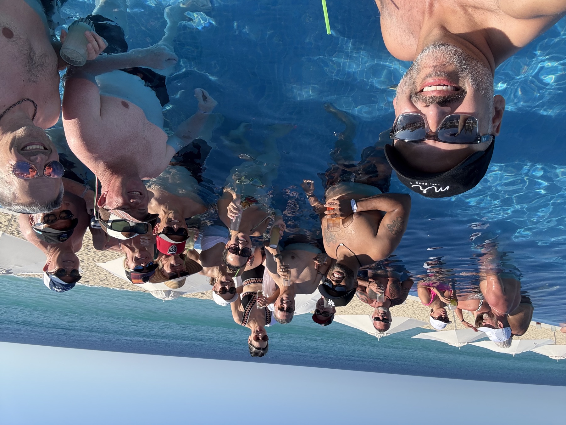 The whole crew with drinks in the infinity pool above the beach