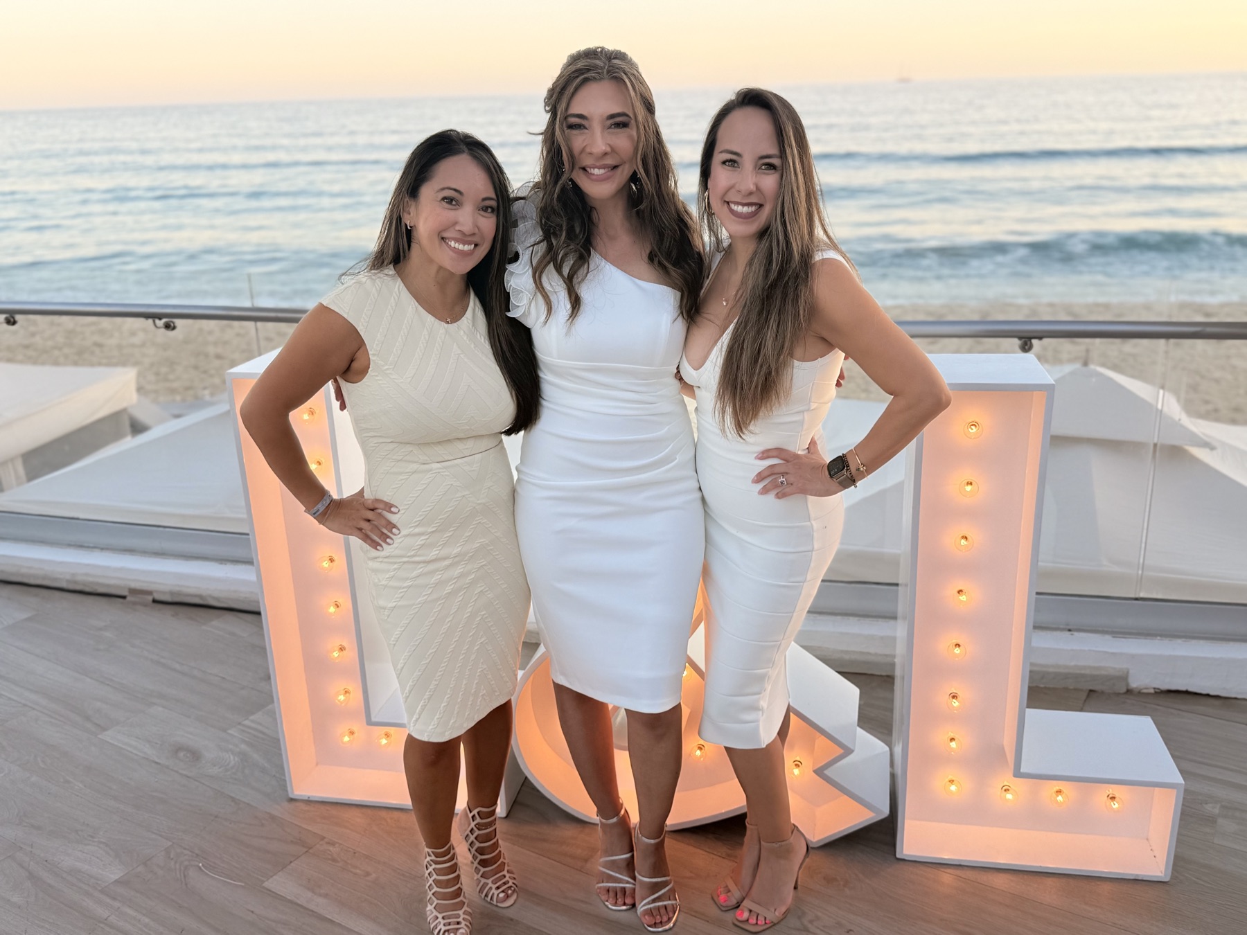 Three of our girls with the marquee letters at sunset